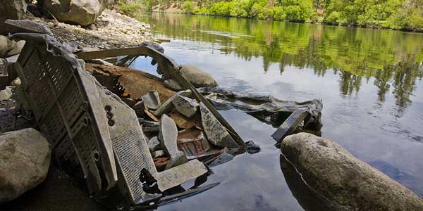 body of water with old computer and trash